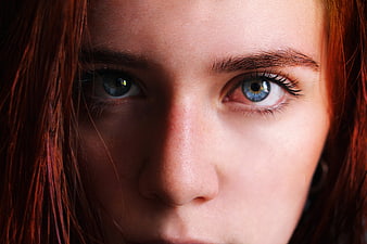 Close-up portrait of a woman with red hair and blue eyes