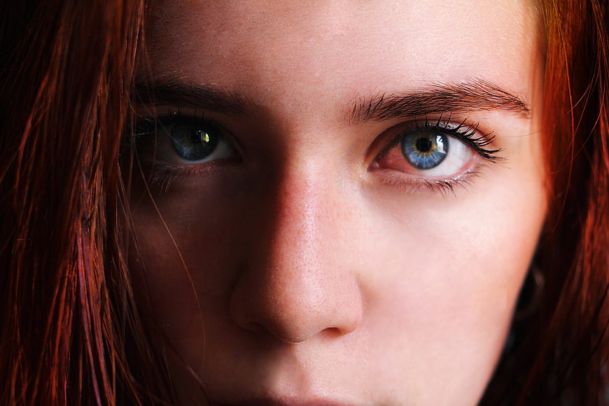 Close-up portrait of a woman with red hair and blue eyes