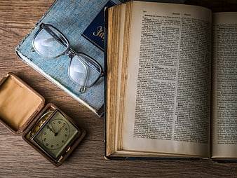 Vintage flat lay with old book, glasses, and pocket watch