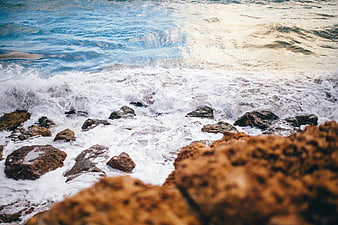 Ocean Waves Crashing on Rocky Shore at Sunset