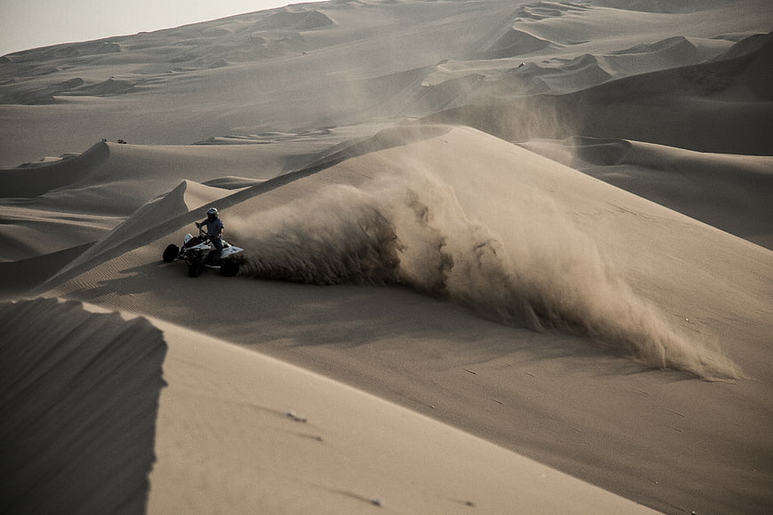 ATV Rider Kicking Up Sand on Desert Dunes