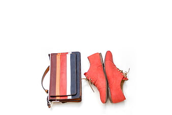 Colorful striped leather bag and red suede shoes flat lay