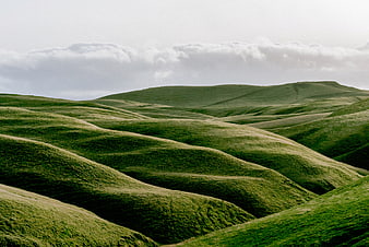 Rolling Green Hills Landscape with Cloudy Sky
