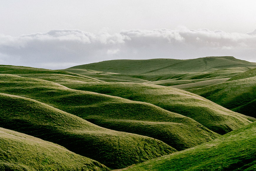 Rolling Green Hills Landscape with Cloudy Sky