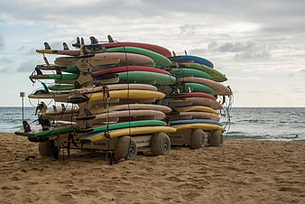 Stack of colorful surfboards on a rack at the beach