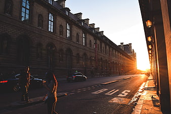 Paris street at sunset with golden light and pedestrians