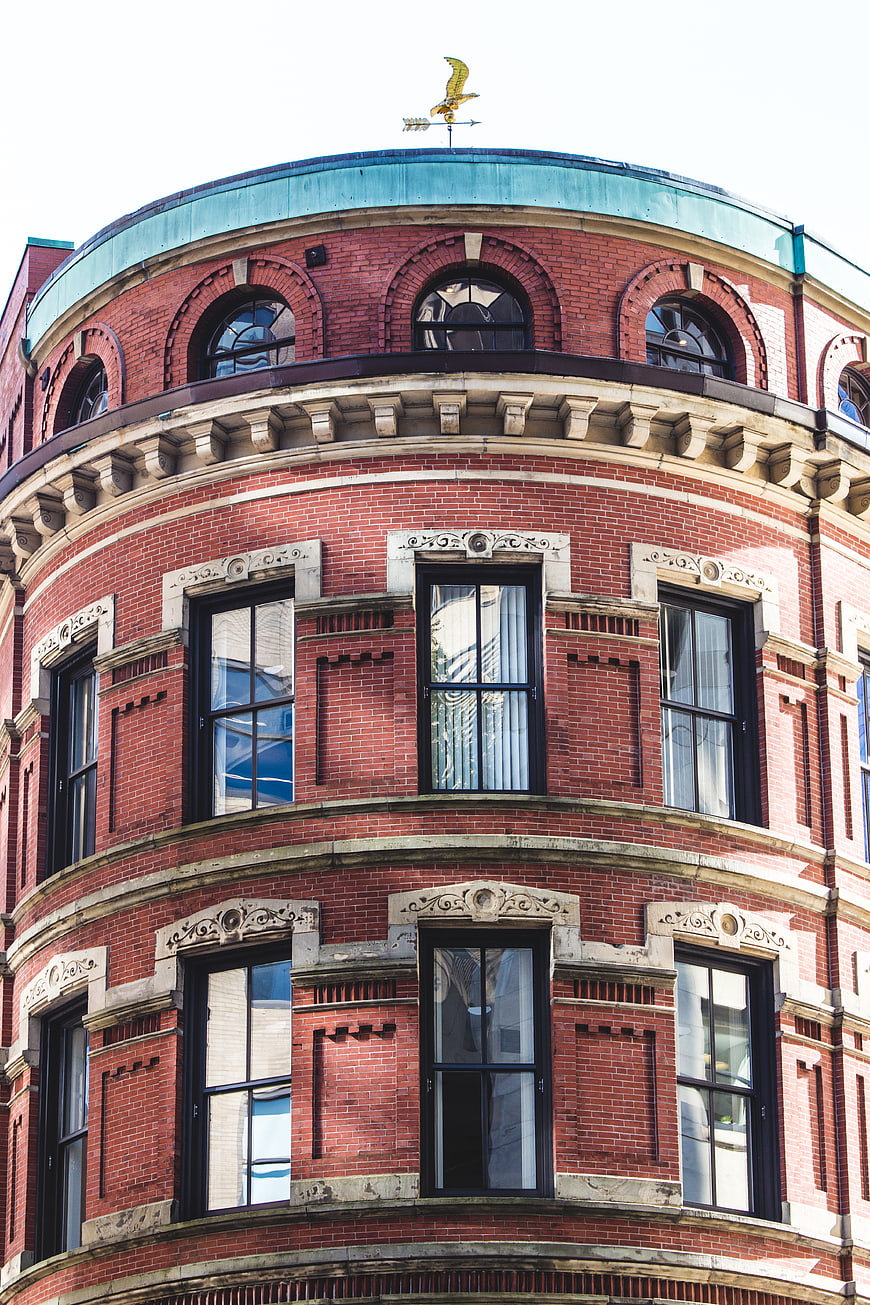 Red Brick Corner Building with Arched Windows and Weathervane