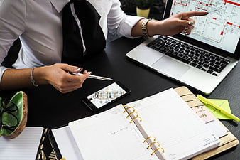 Businesswoman Reviewing Architectural Plans on Laptop