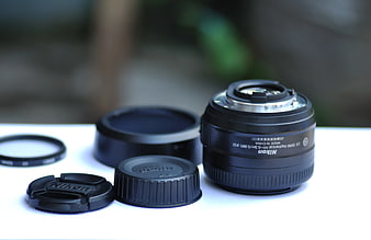 Nikon Camera Lens and Accessories on White Surface