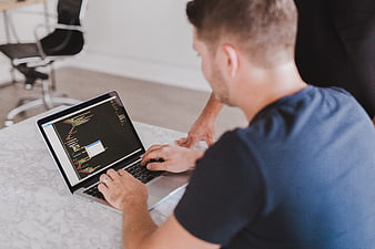 Programmer coding on laptop in modern office workspace