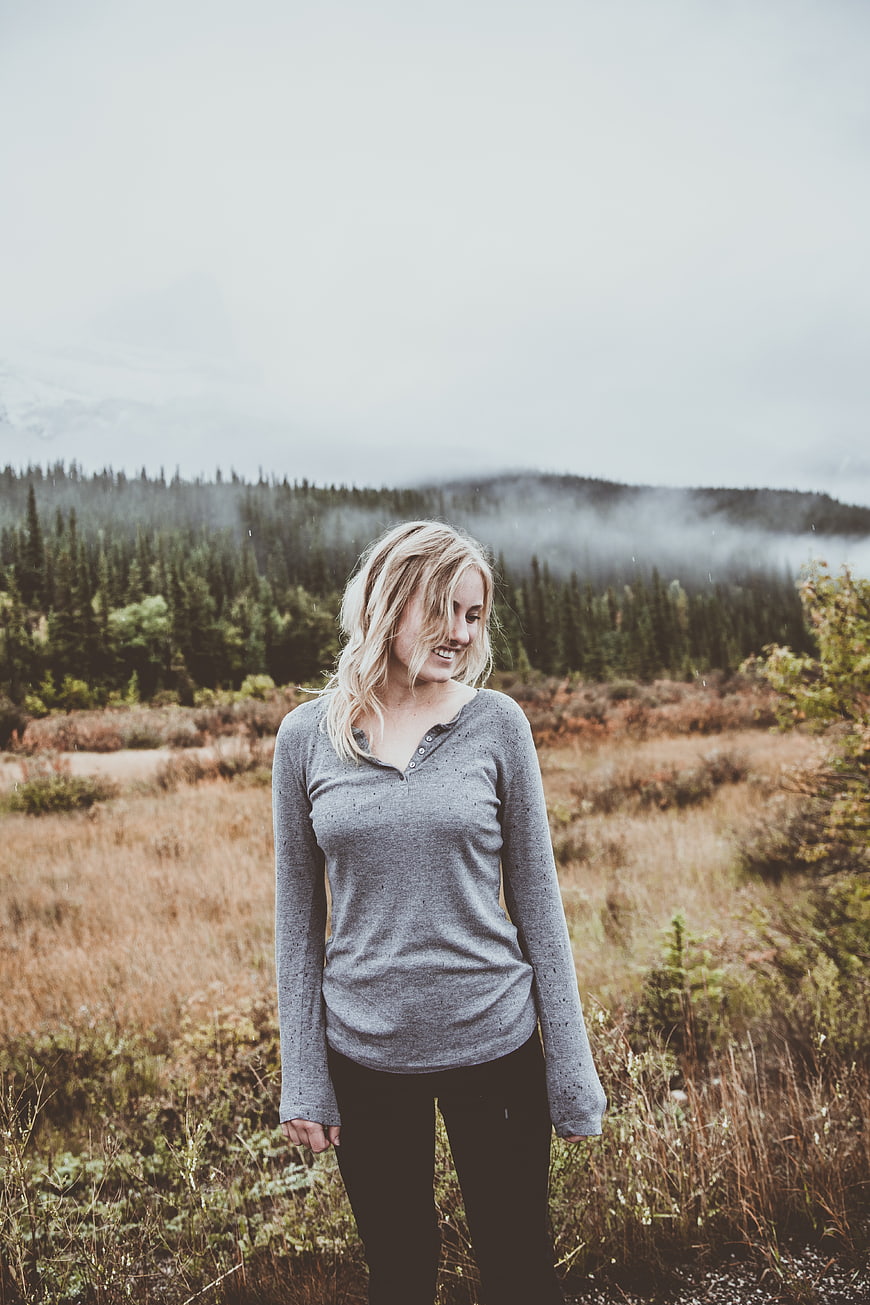 Blonde woman smiling in misty autumn mountain landscape