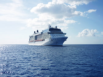 Large white cruise ship sailing on blue ocean under sunny sky