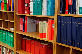Colorful Law Books on Wooden Shelves in Library