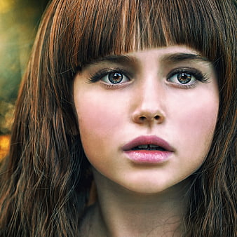 Close-up portrait of a young woman with bangs and natural makeup
