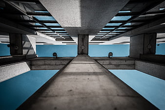 Low angle view of brutalist concrete architecture against blue sky