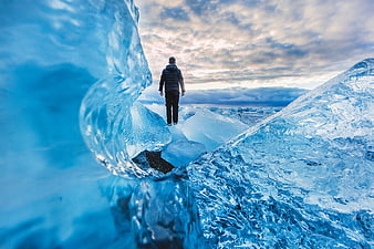 Man walking on blue ice glacier landscape