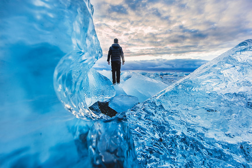 Man walking on blue ice glacier landscape