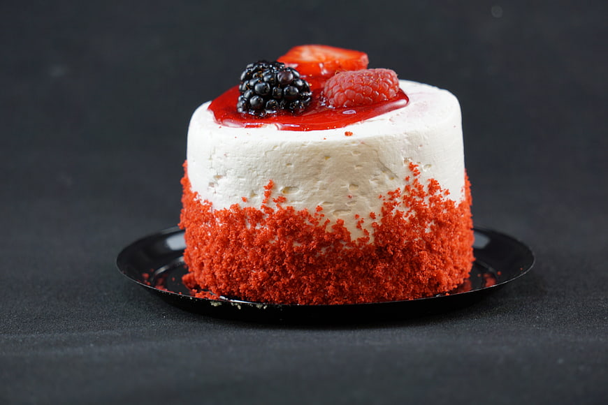 Red Velvet Cheesecake With Fresh Berries On Black Plate