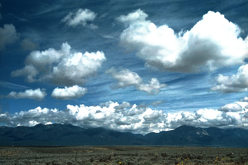 Vast desert landscape with dramatic clouds and distant mountains
