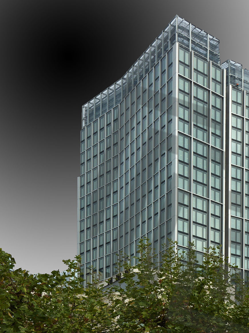 Modern Glass Skyscraper with Green Trees in Foreground