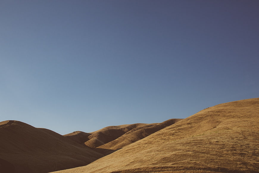 Golden rolling hills under a clear blue sky