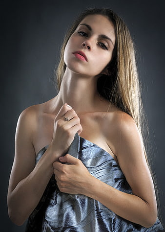 Elegant woman in silver dress with dramatic studio lighting
