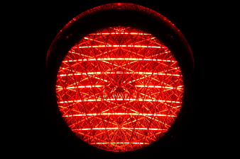 Close-up of glowing red traffic stop light lens