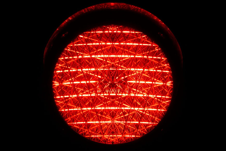 Close-up of glowing red traffic stop light lens