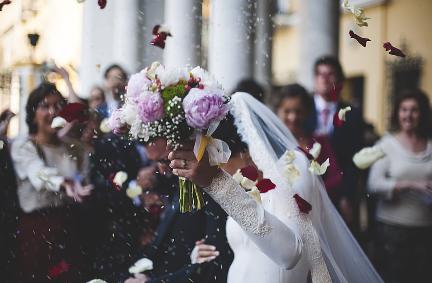 Bride and Groom Kissing Amidst Falling Flower Petals