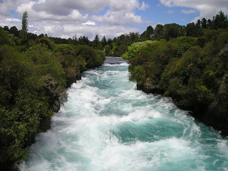 Turquoise River Rapids Flowing Through Lush Green Forest