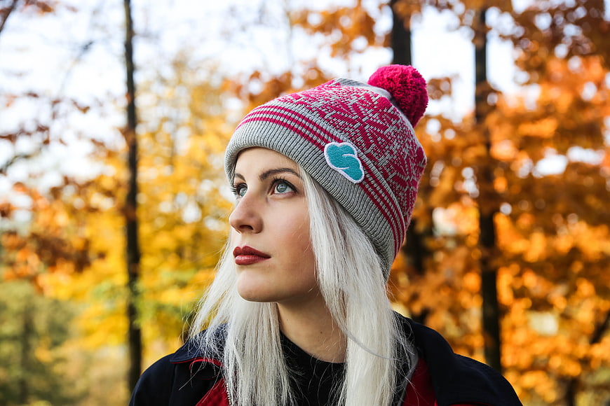 Woman in Pink Knit Beanie Looking Up in Autumn Forest