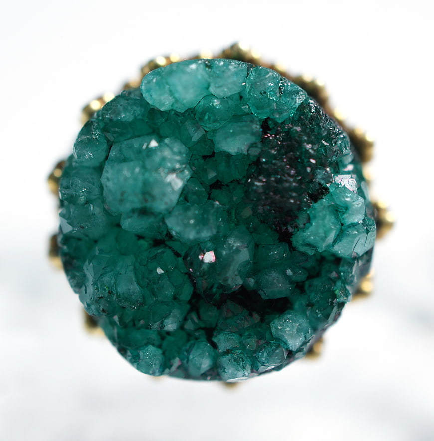 Macro shot of a green druzy quartz ring with gold setting