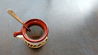 Top view of ceramic coffee cup with spoon on gray table
