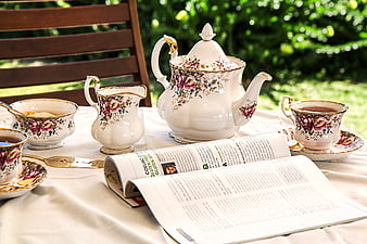 Vintage Floral Tea Set on Outdoor Table with Magazine