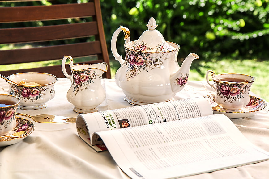 Vintage Floral Tea Set on Outdoor Table with Magazine