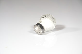 Glass Salt Shaker With Metal Lid On White Background