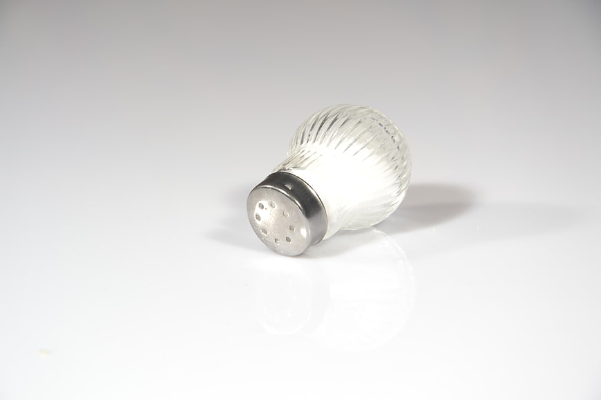 Glass Salt Shaker With Metal Lid On White Background