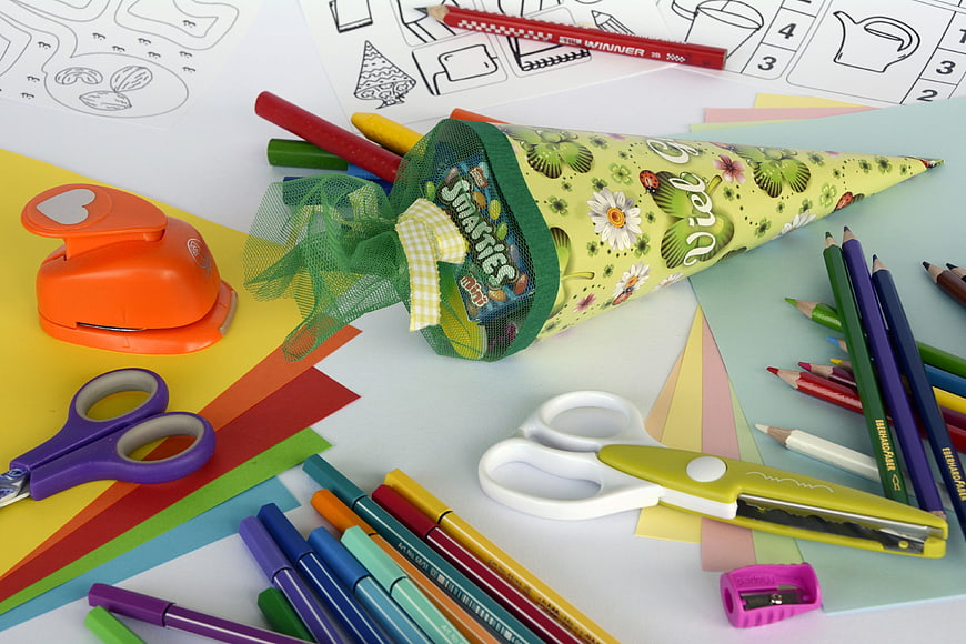 Colorful school supplies and party favor cone on craft paper