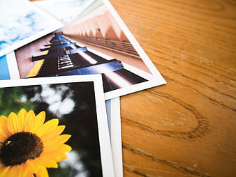 Stack of printed photographs on wooden table