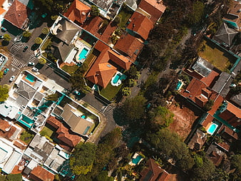 Aerial view of suburban neighborhood with red roofs and pools