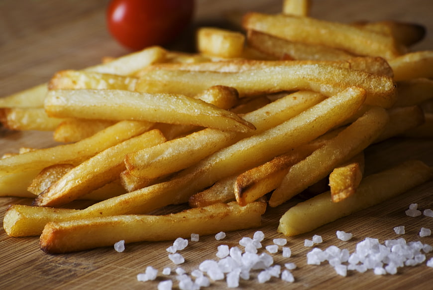 Golden French Fries with Sea Salt on Wooden Board