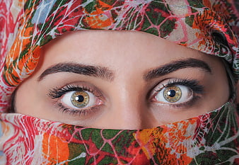 Close-up portrait of a woman wearing a colorful floral headscarf