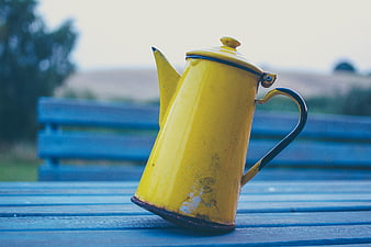 Vintage Yellow Enamel Kettle on Blue Wooden Bench