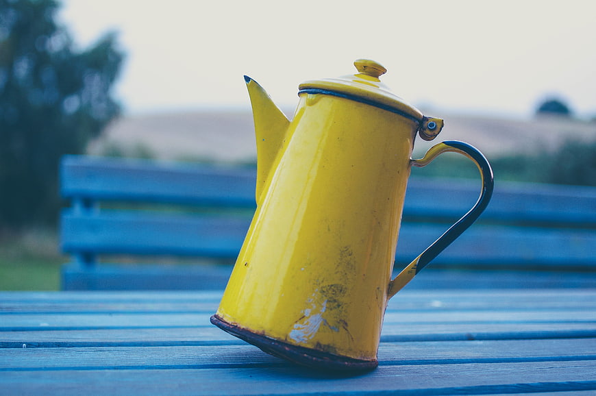 Vintage Yellow Enamel Kettle on Blue Wooden Bench