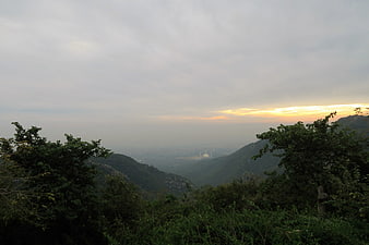 Mountain View Over Hazy Valley With Distant City At Sunset