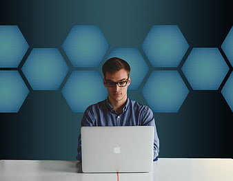 Young professional working on a laptop in a modern blue office