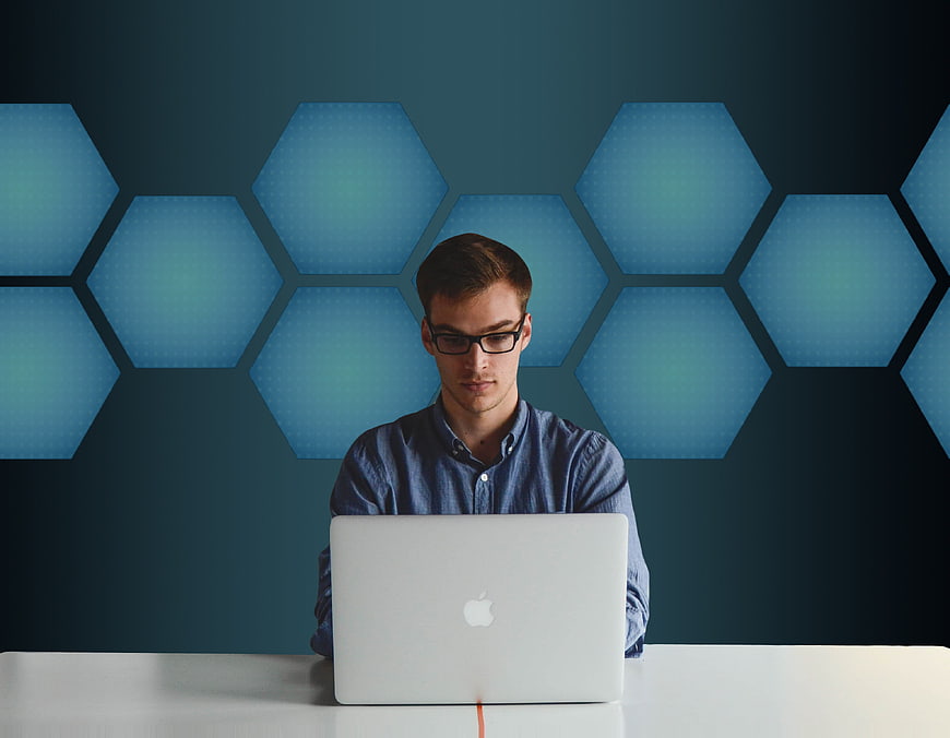 Young professional working on a laptop in a modern blue office