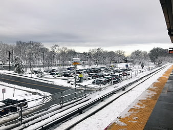 Snowy Train Station Platform with Parking Lot and Tracks