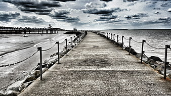 Dramatic Black and White Coastal Pier Leading to Horizon