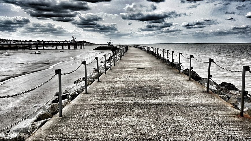 Dramatic Black and White Coastal Pier Leading to Horizon